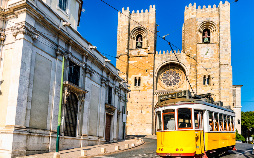 Historic yellow tram in front of the Lisbon Cathedral